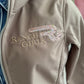 Beige jacket with 'Ranch Girls' and design on a blurred background