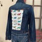 Denim jacket with horse pattern on the back, displayed against a neutral wall.