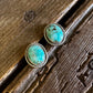 Turquoise stud earrings on a wooden surface