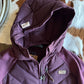 Purple jacket with a brand logo on a patterned surface