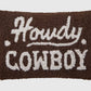 Textile pillow with 'Howdy Cowboy' text on a brown background