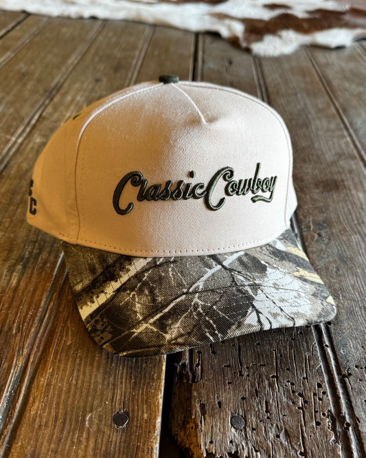 hat on a wooden surface, one beige with 'Classic Cowboy' text and one camouflage-patterned.
