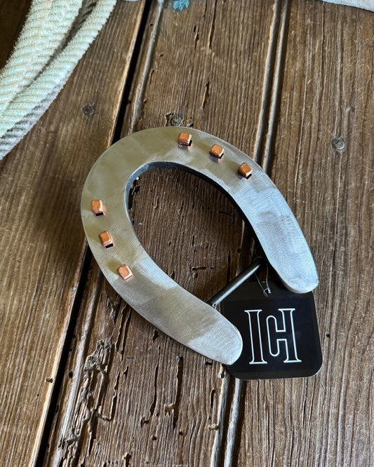 Horseshoe with a black tag on a wooden surface
