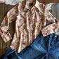 Floral shirt and denim jeans on a wooden surface with cowhide rug