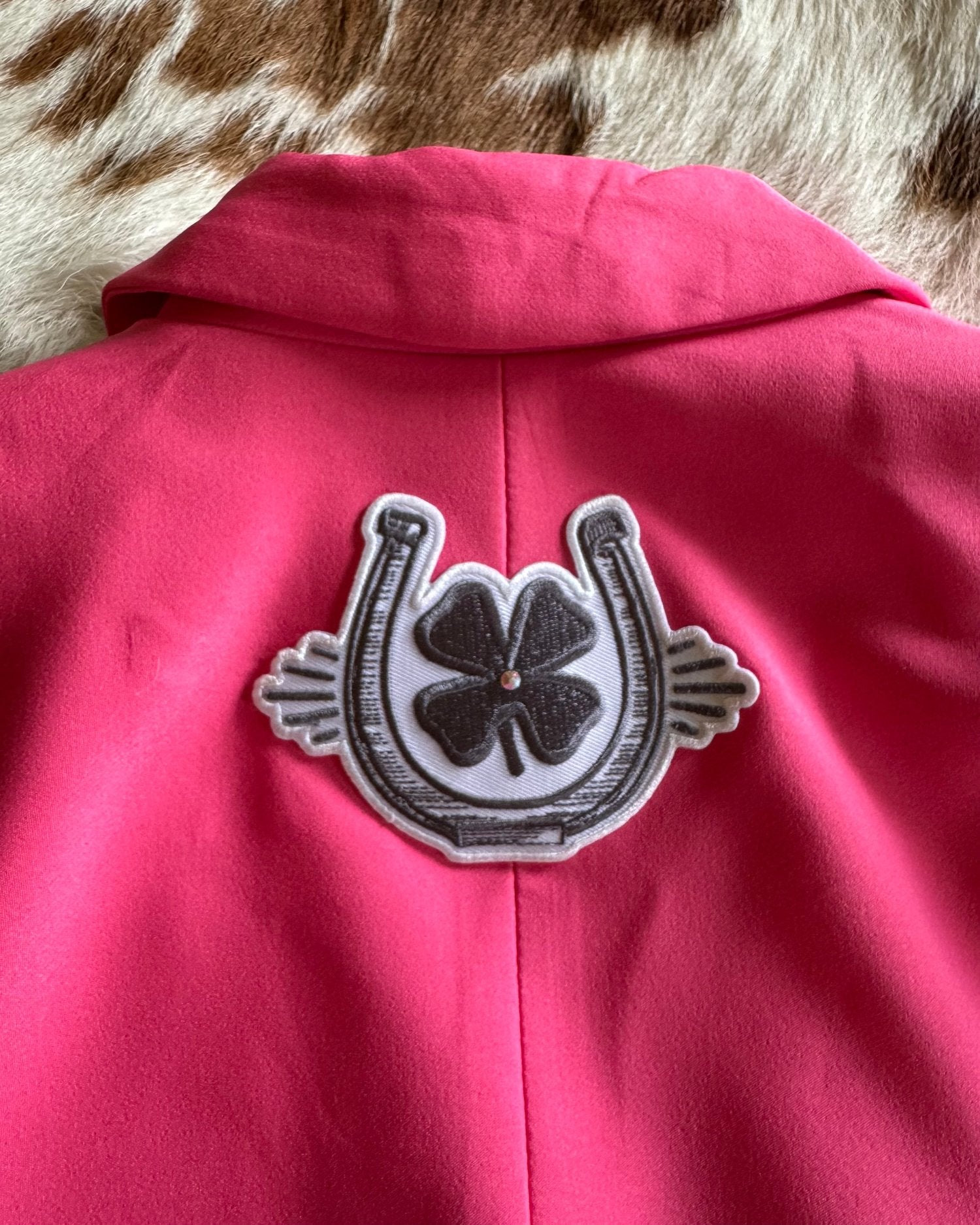 Charcoal clover and horse shoe with bling on back of blazer