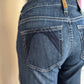 Blue jeans with a visible brand tag on the back pocket against a neutral background