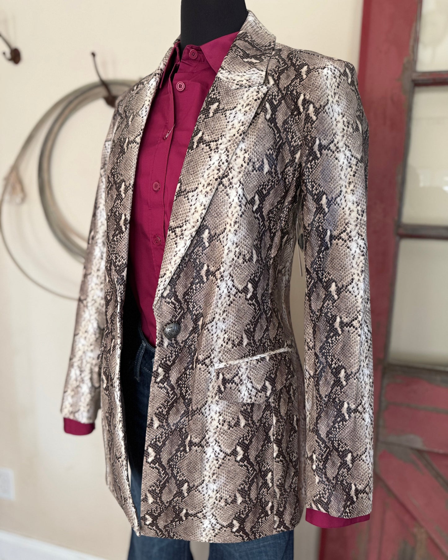 Snakeskin patterned jacket on a mannequin against a neutral background