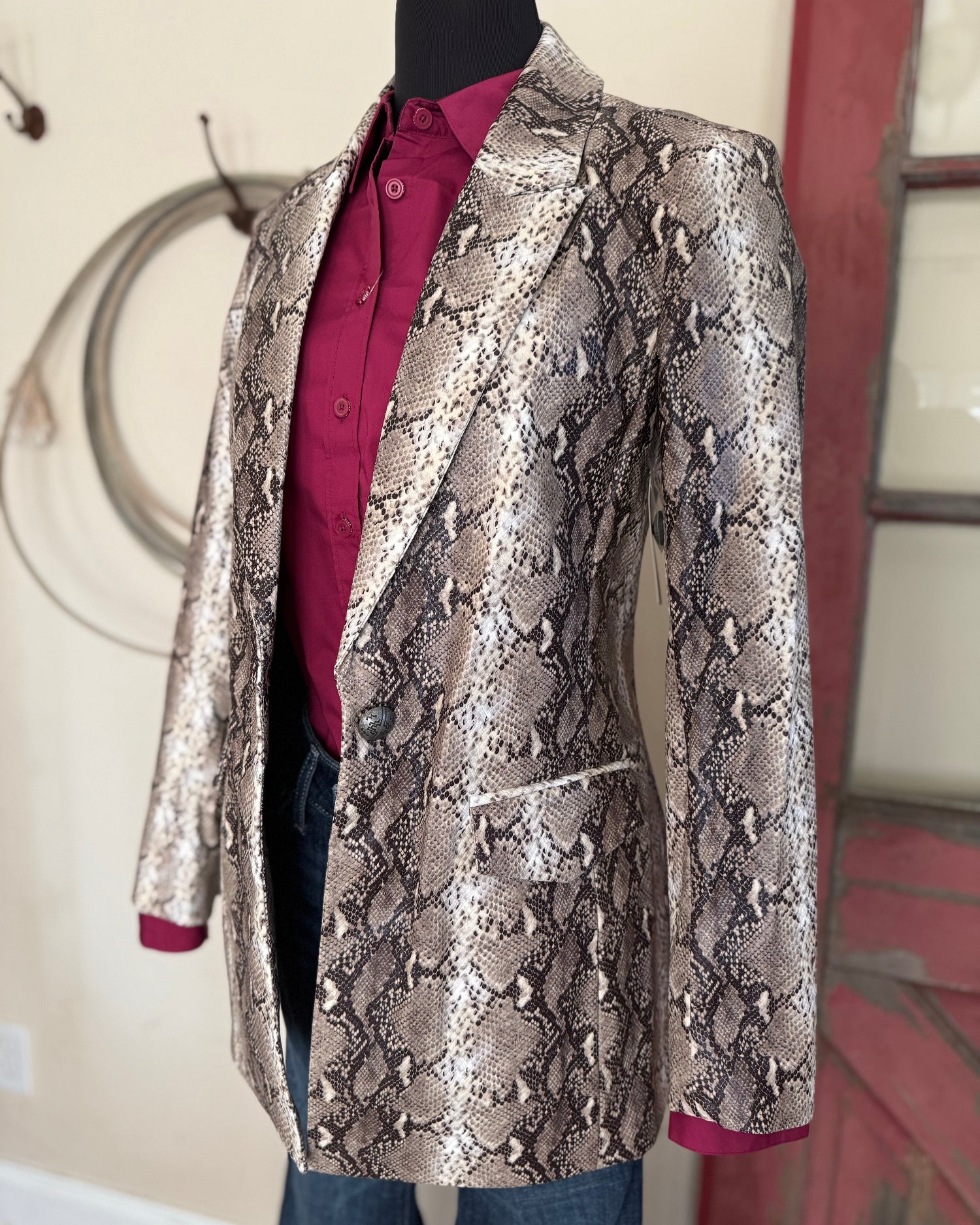 Snakeskin patterned jacket on a mannequin against a neutral background