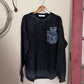 Black sweatshirt with a logo on a white surface