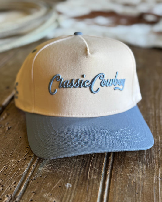 Beige and blue cap with 'Classic Cowboy' text on a wooden surface