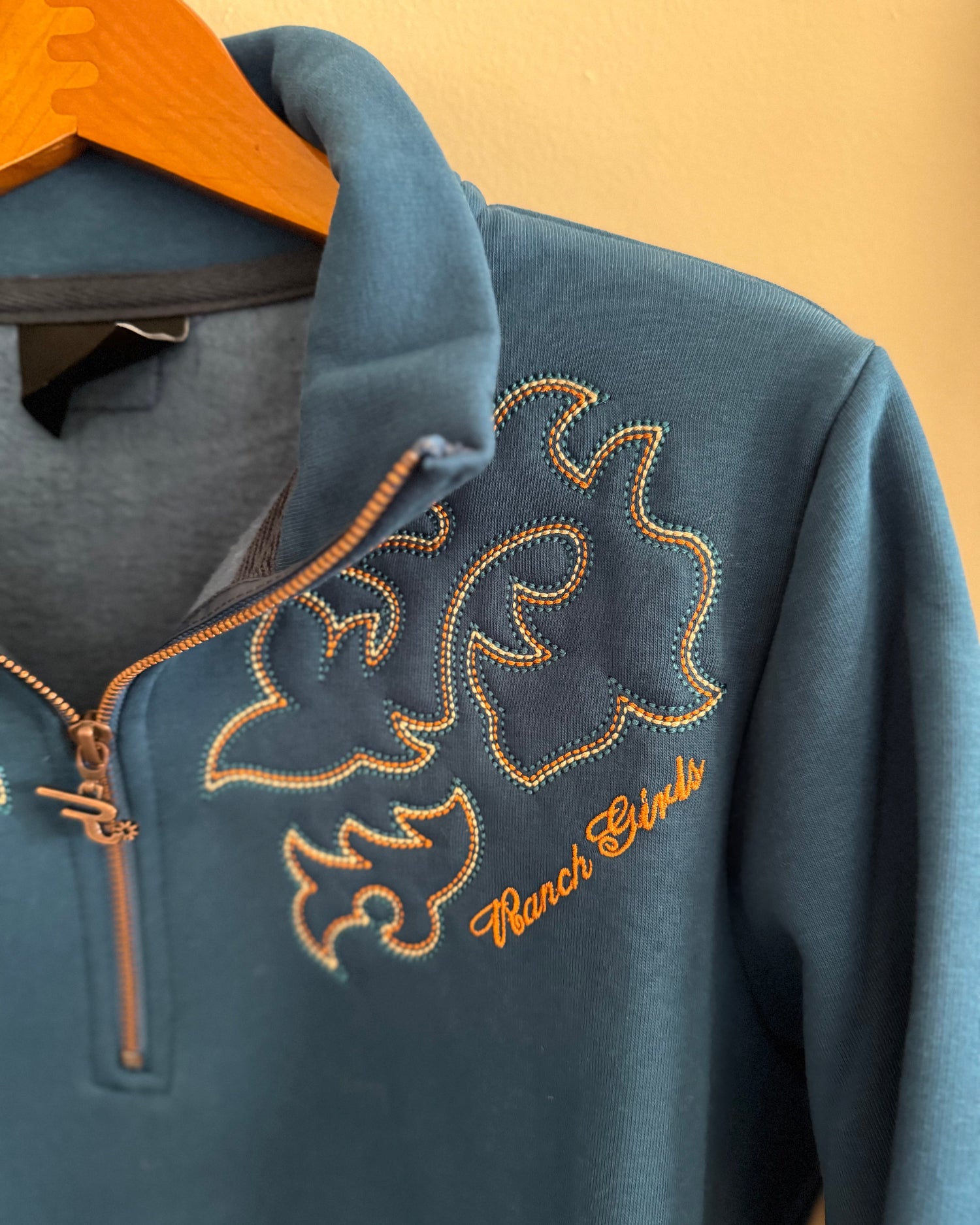 Blue sweatshirt with embroidered design and 'Ranch Girls' text on a yellow background