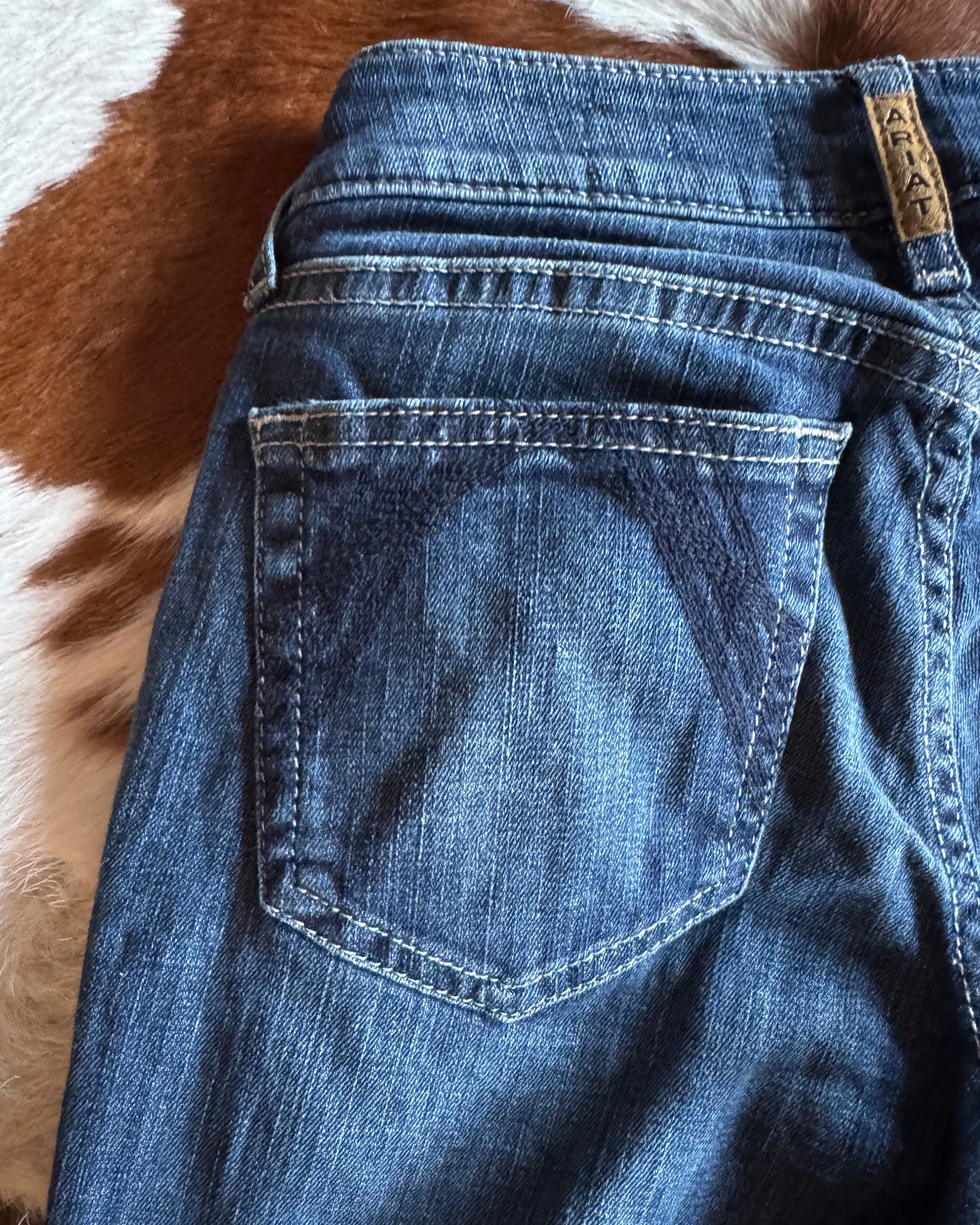 Close-up of blue jeans with a brand label on a patterned surface