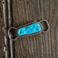 Turquoise stone twilly slide on a wooden surface