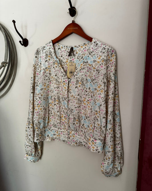 Folded floral-patterned garment on a hanger against a white background