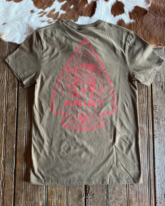 Green t-shirt with red graphic design on a wooden surface with cowhide rug