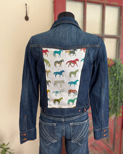 Denim jacket with horse pattern on the back, displayed against a neutral background.