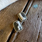 Pair of earrings with stone and gold accents on a wooden surface