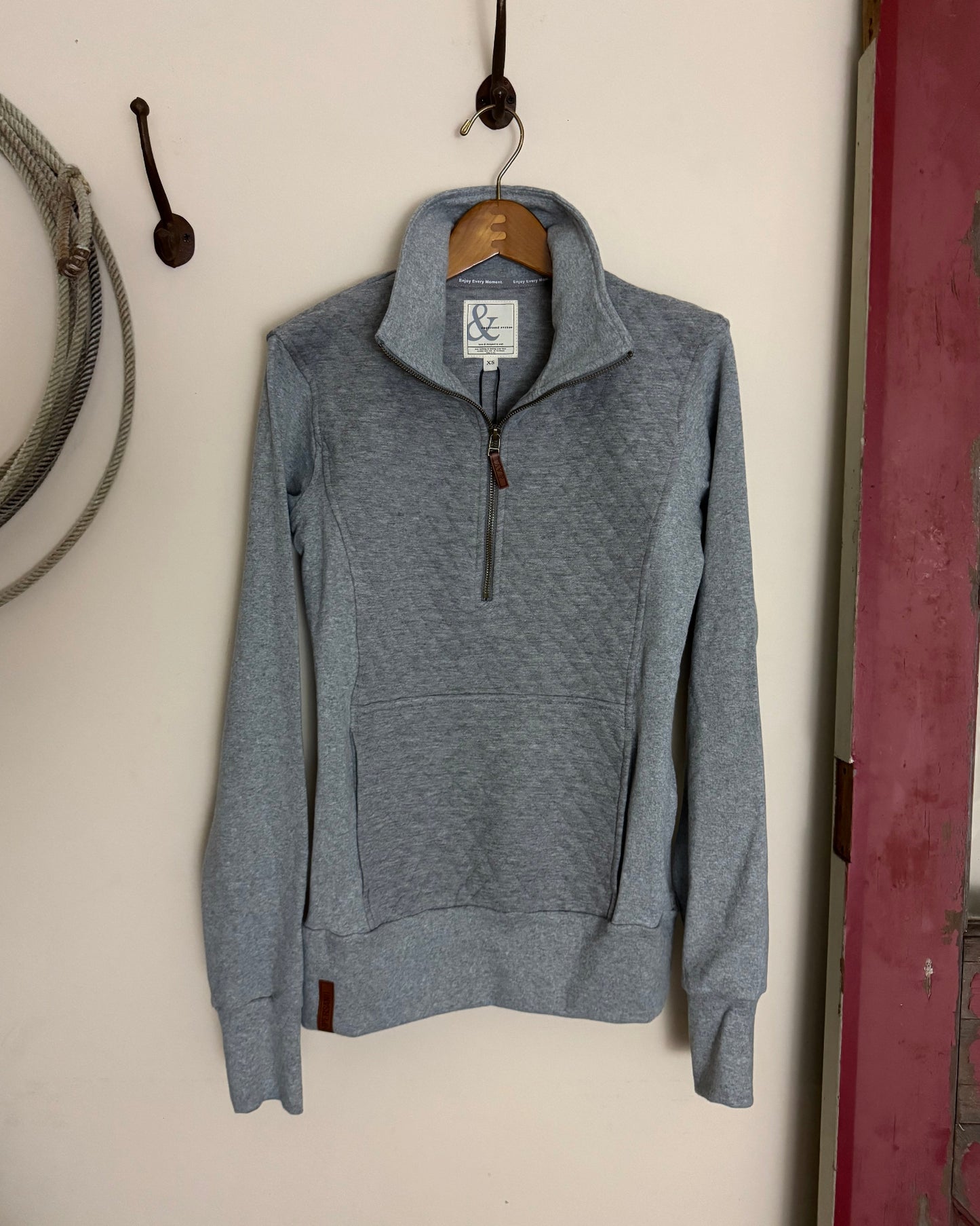 Gray hoodie on a white surface with a blurred background