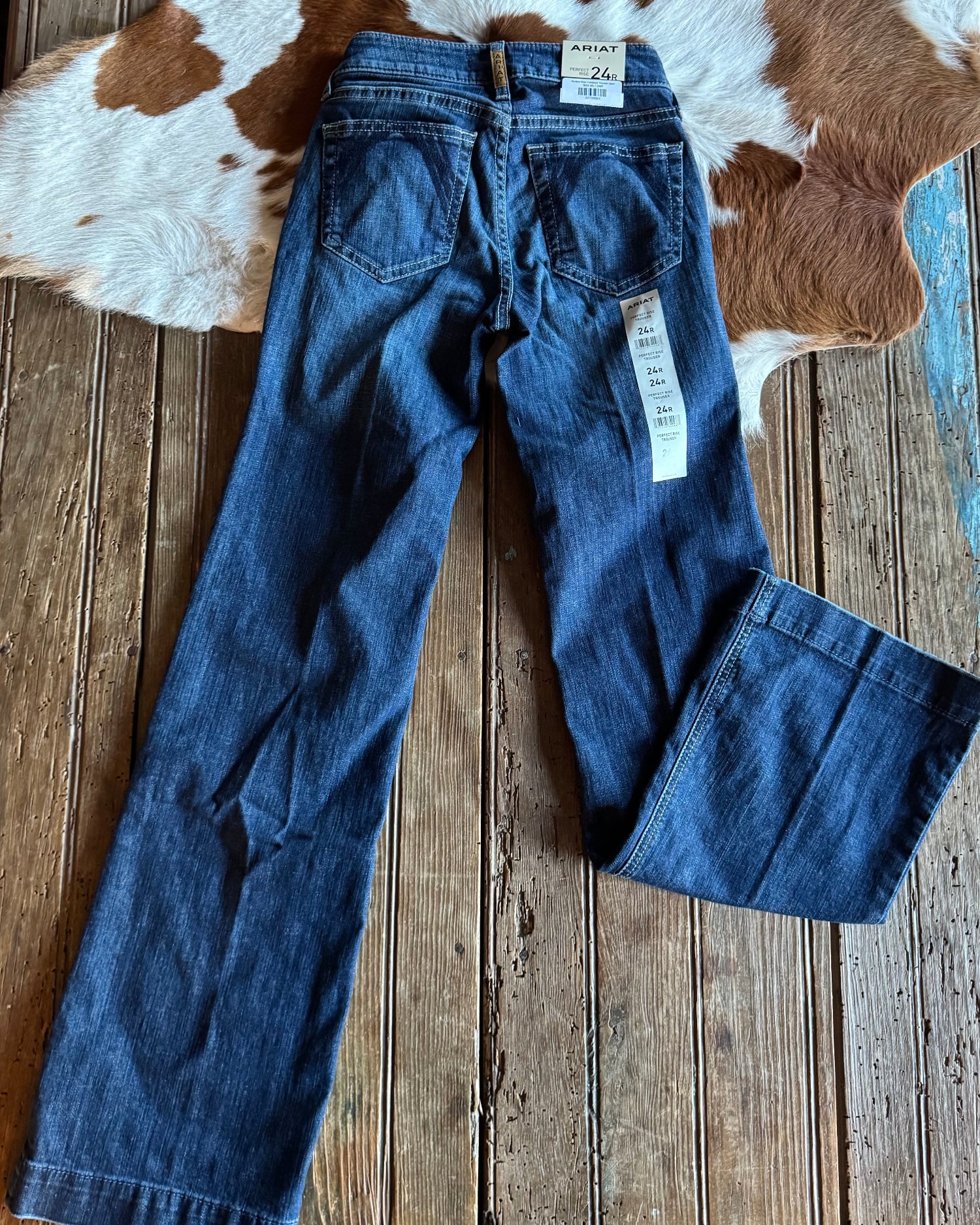 jeans laying on a wooden background with a cowhide 