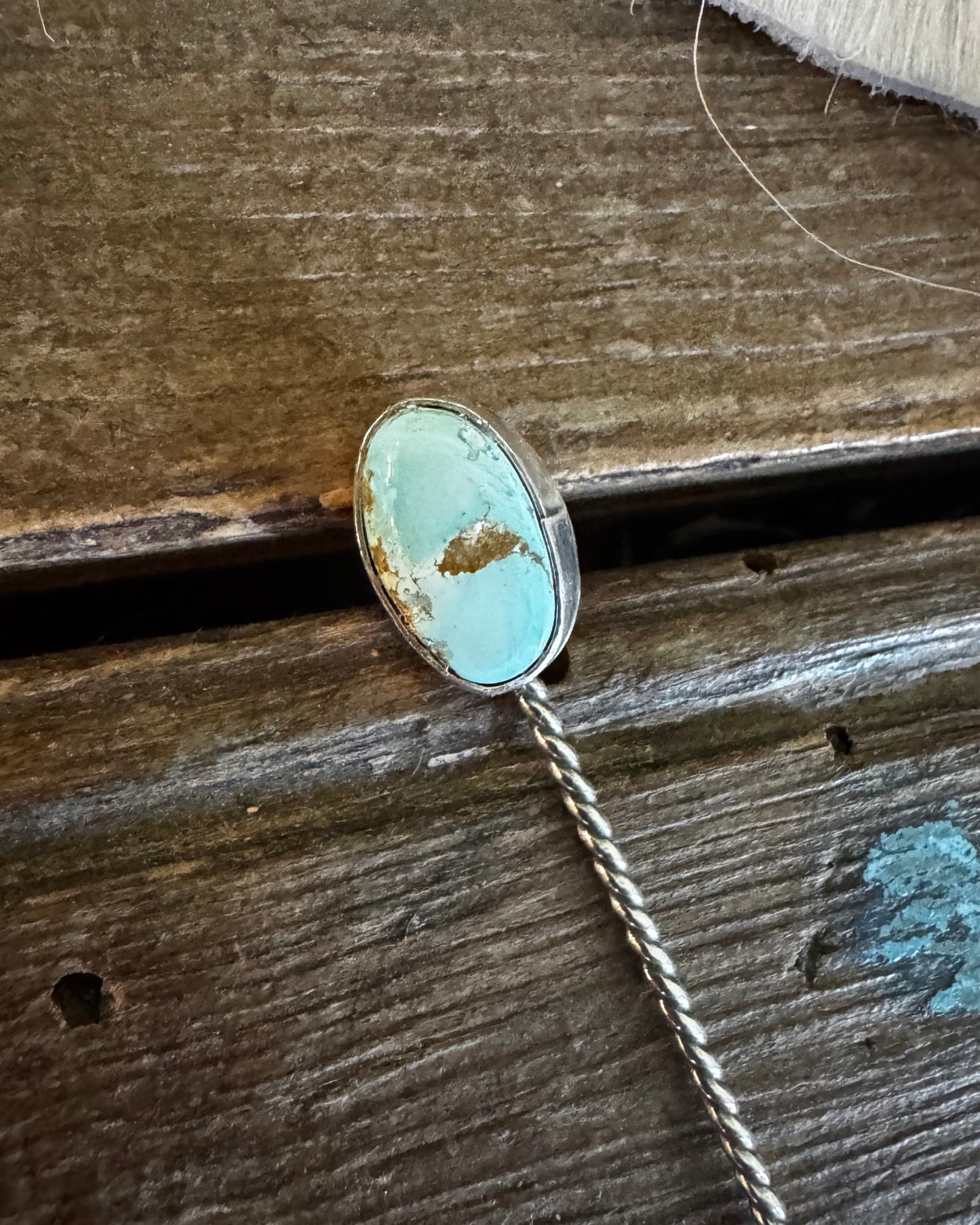 Necklace with a turquoise pendant on a wooden surface