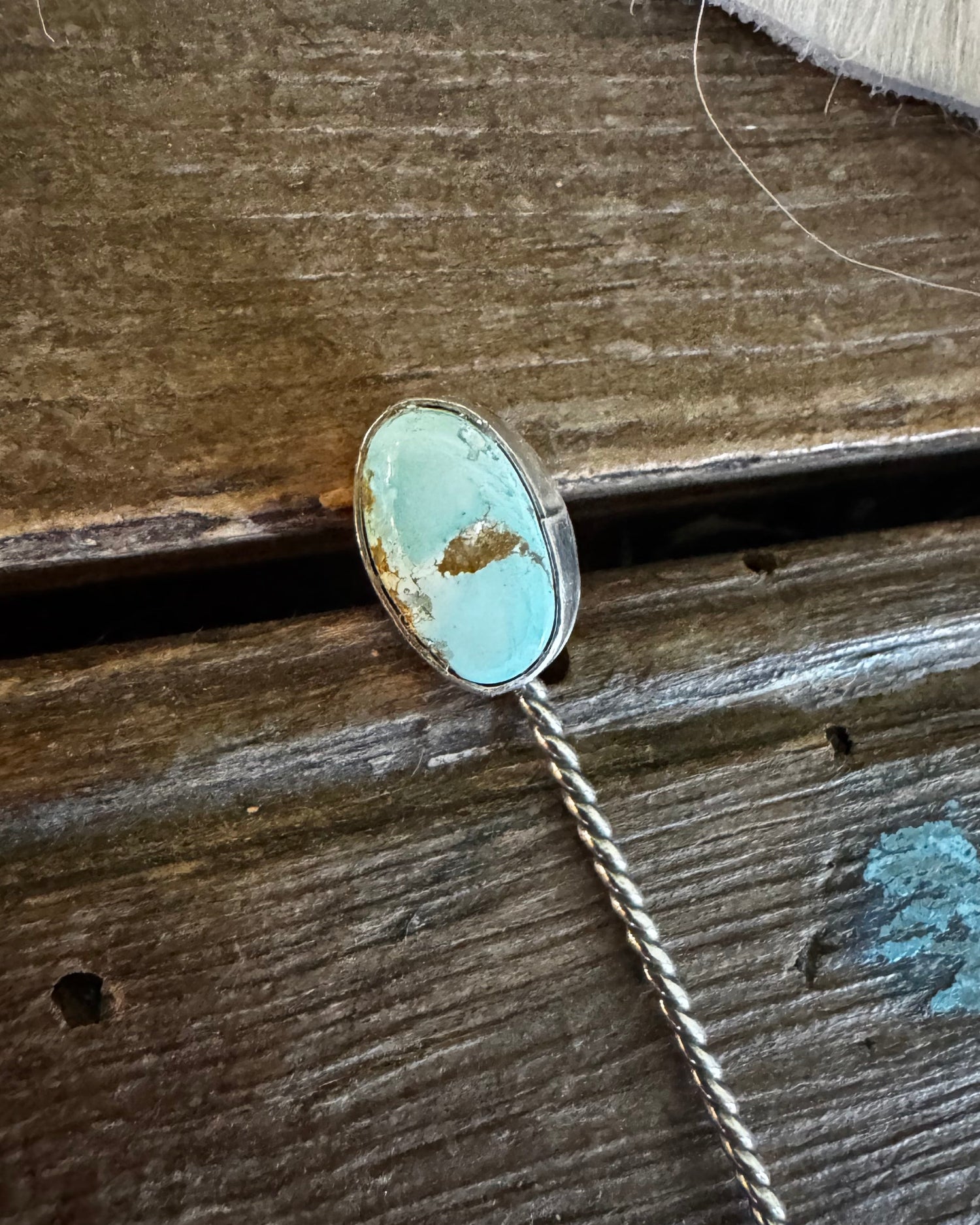 Necklace with a turquoise pendant on a wooden surface