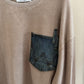 Beige sweater with a denim pocket and 'MoonRyder' label on a white background