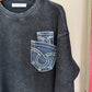 Dark gray t-shirt with a brand logo on a wooden hanger against a white background