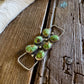 Jewelry with green stones on a wooden surface