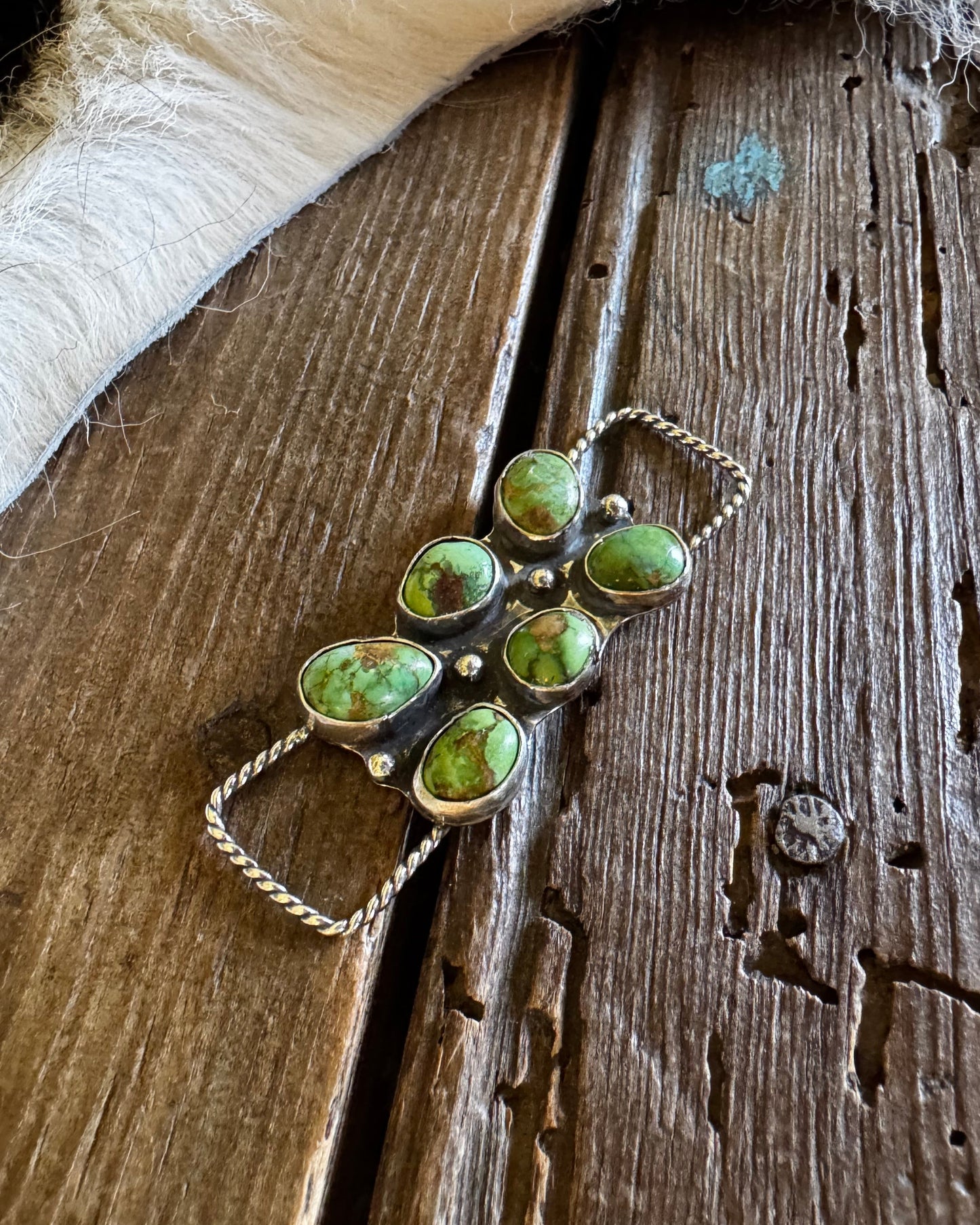 Jewelry with green stones on a wooden surface