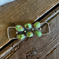 Jewelry with green stones on a wooden surface
