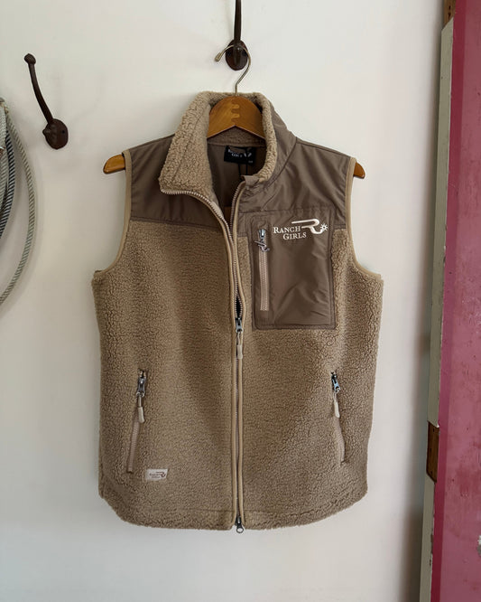 Brown vest with 'Ranch Girls' logo hanging on a hook against a white wall.