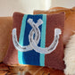 Decorative pillow with horse shoes on a brown couch