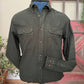Dark green shirt with button details on a stand against a rustic background