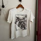 White sweatshirt with black graphic design on a hanger against a white wall.
