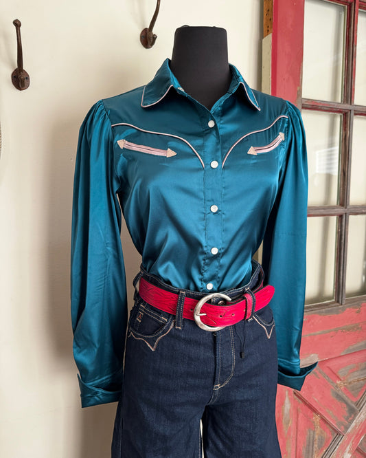Blue satin blouse with a red belt on a chair indoors