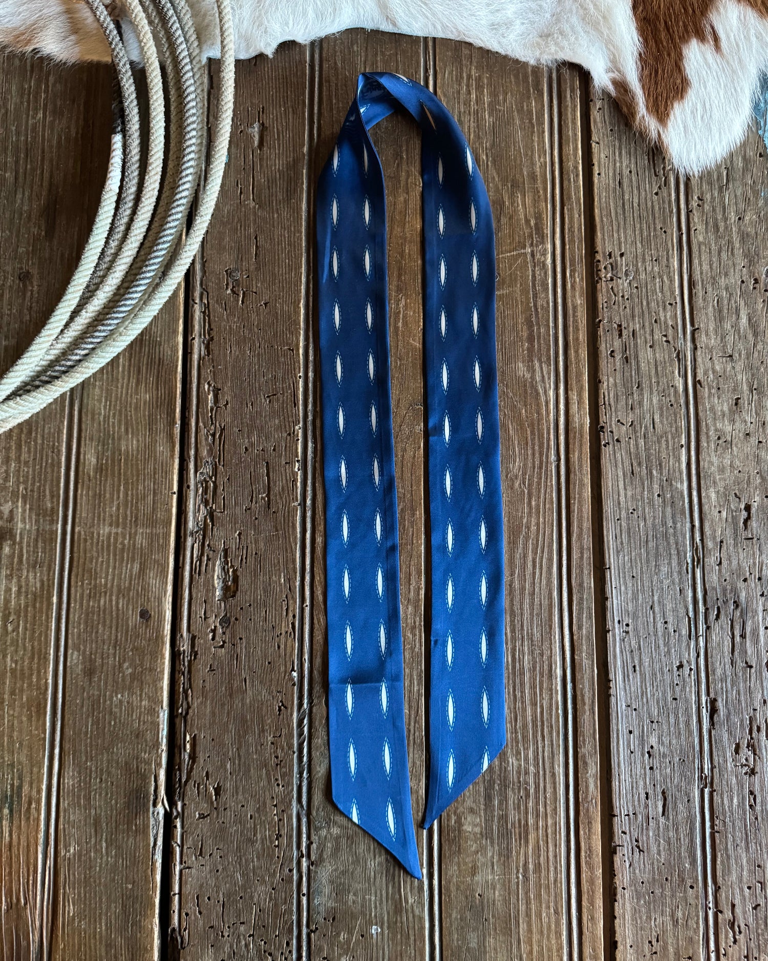 Blue ribbon scarf with white dots on a wooden surface