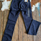 Navy blue jeans with a brand tag on a wooden surface with cowhide rug