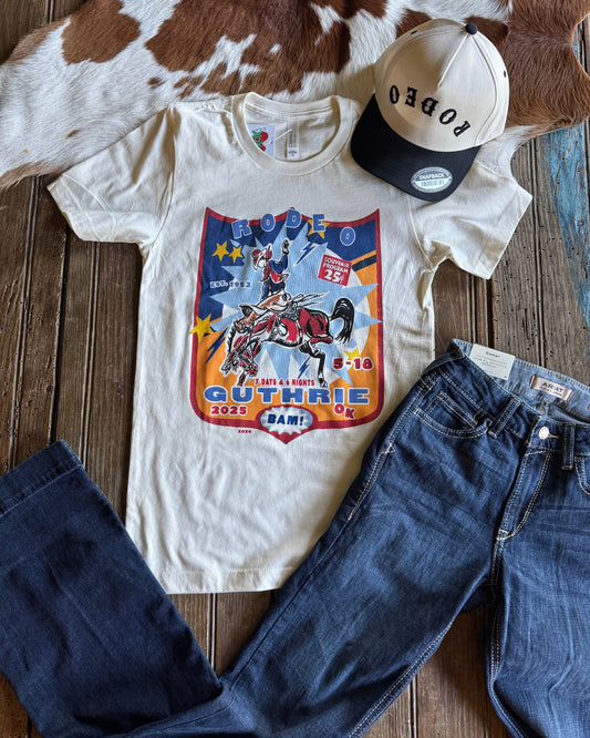 T-shirt with graphic design, cap, and jeans on a wooden surface