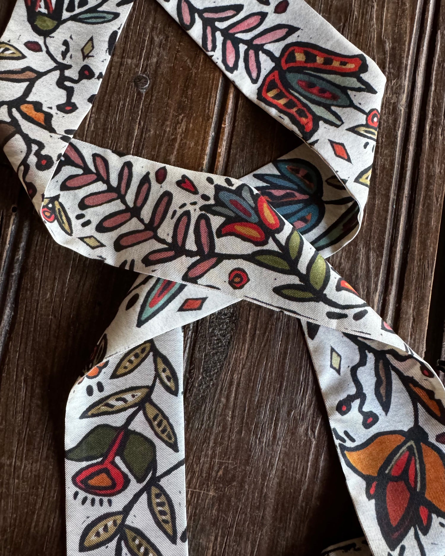 close up of floral twilly scarf on a wooden background