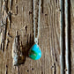 Turquoise pendant necklace on a wooden surface