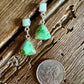 turquoise earrings on a rustic wooden background with a quarter