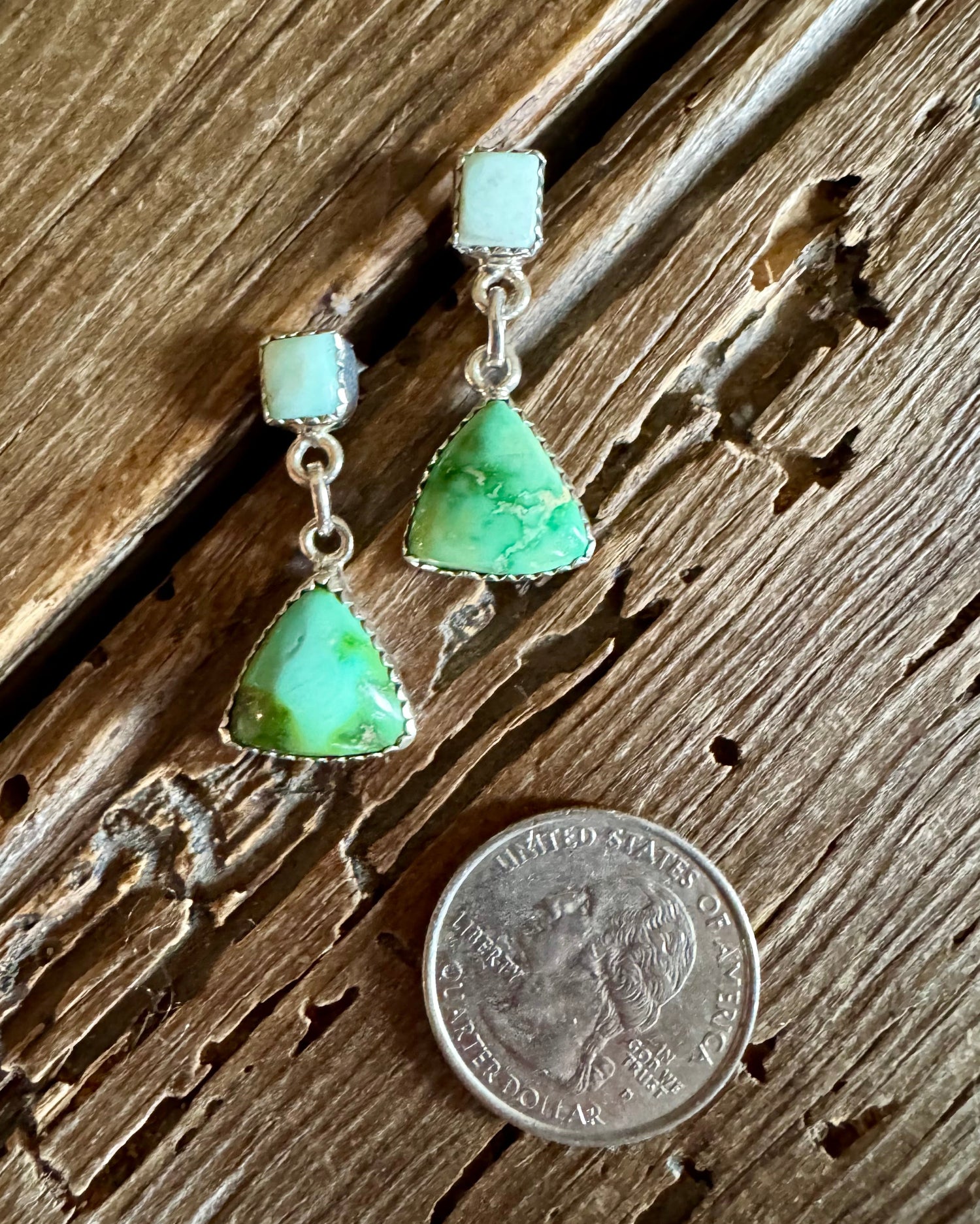 turquoise earrings on a rustic wooden background with a quarter
