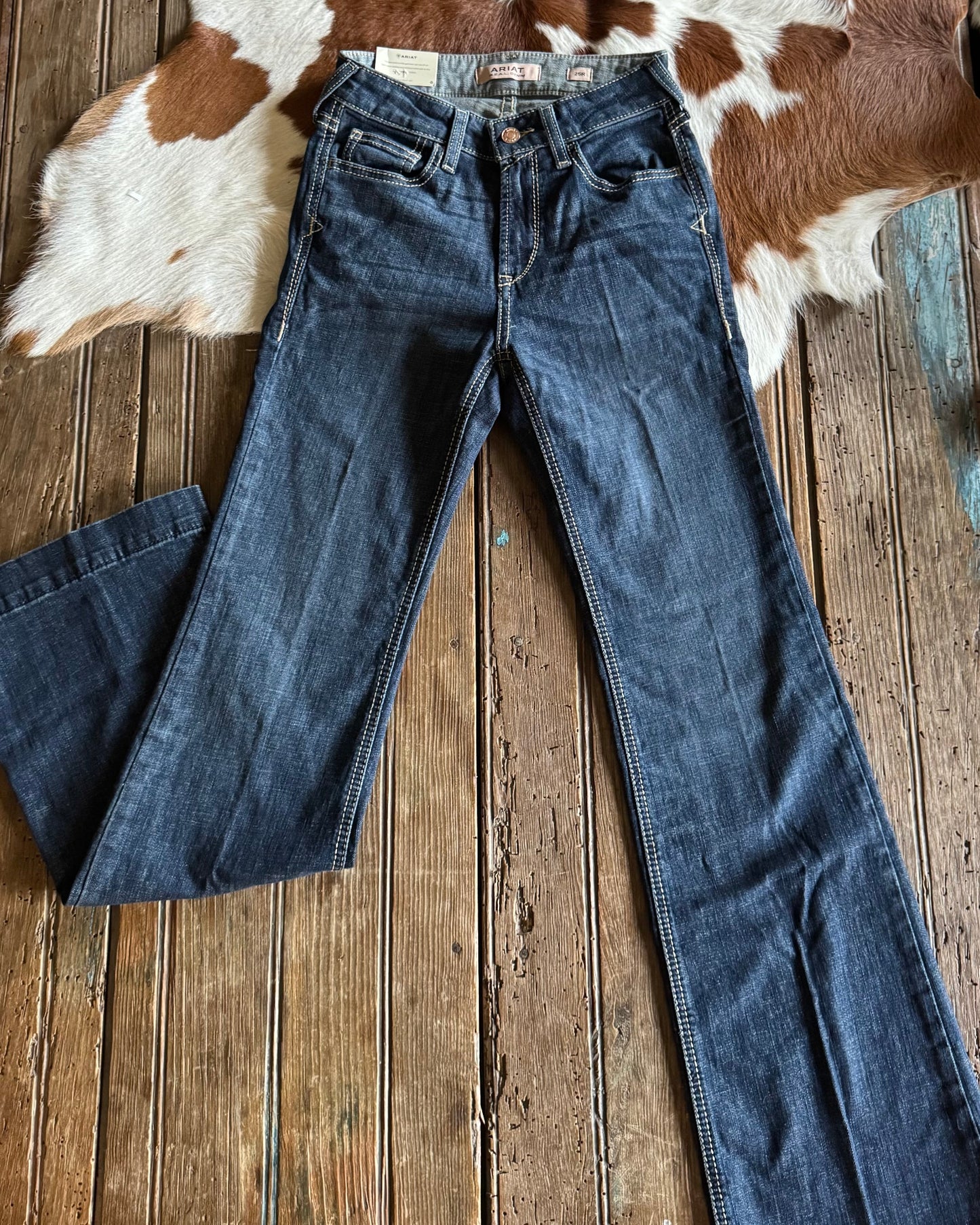 front view of Ella High Rise Slim Trouser Jeans on rustic wood background