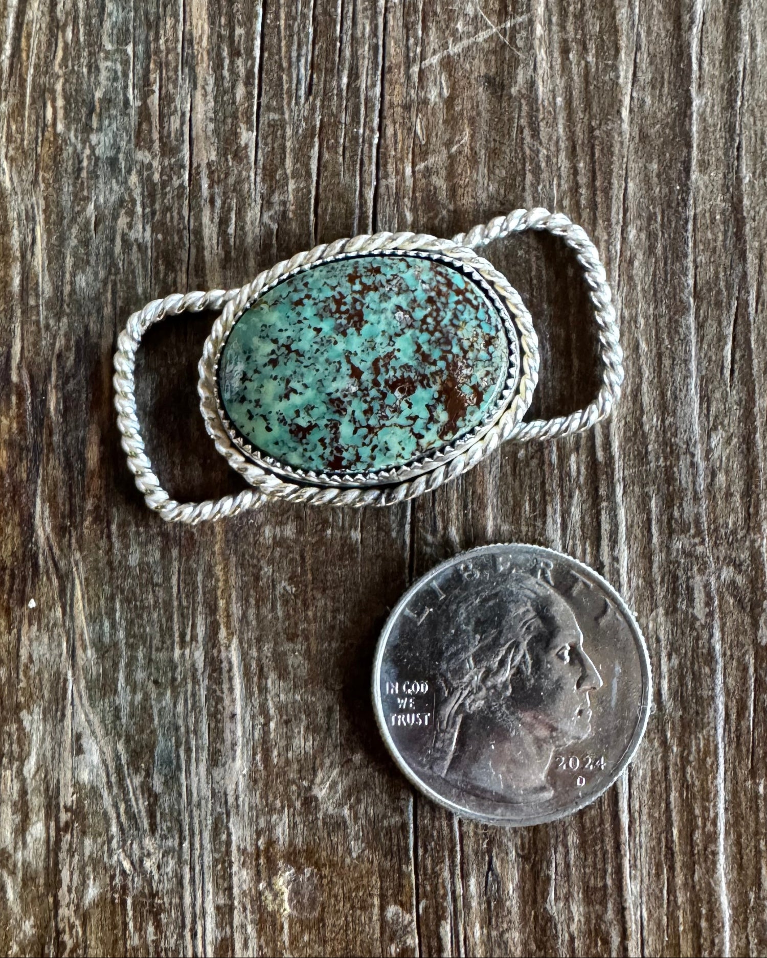 Turquoise stone twilly slide on a wooden surface with a penny for scale