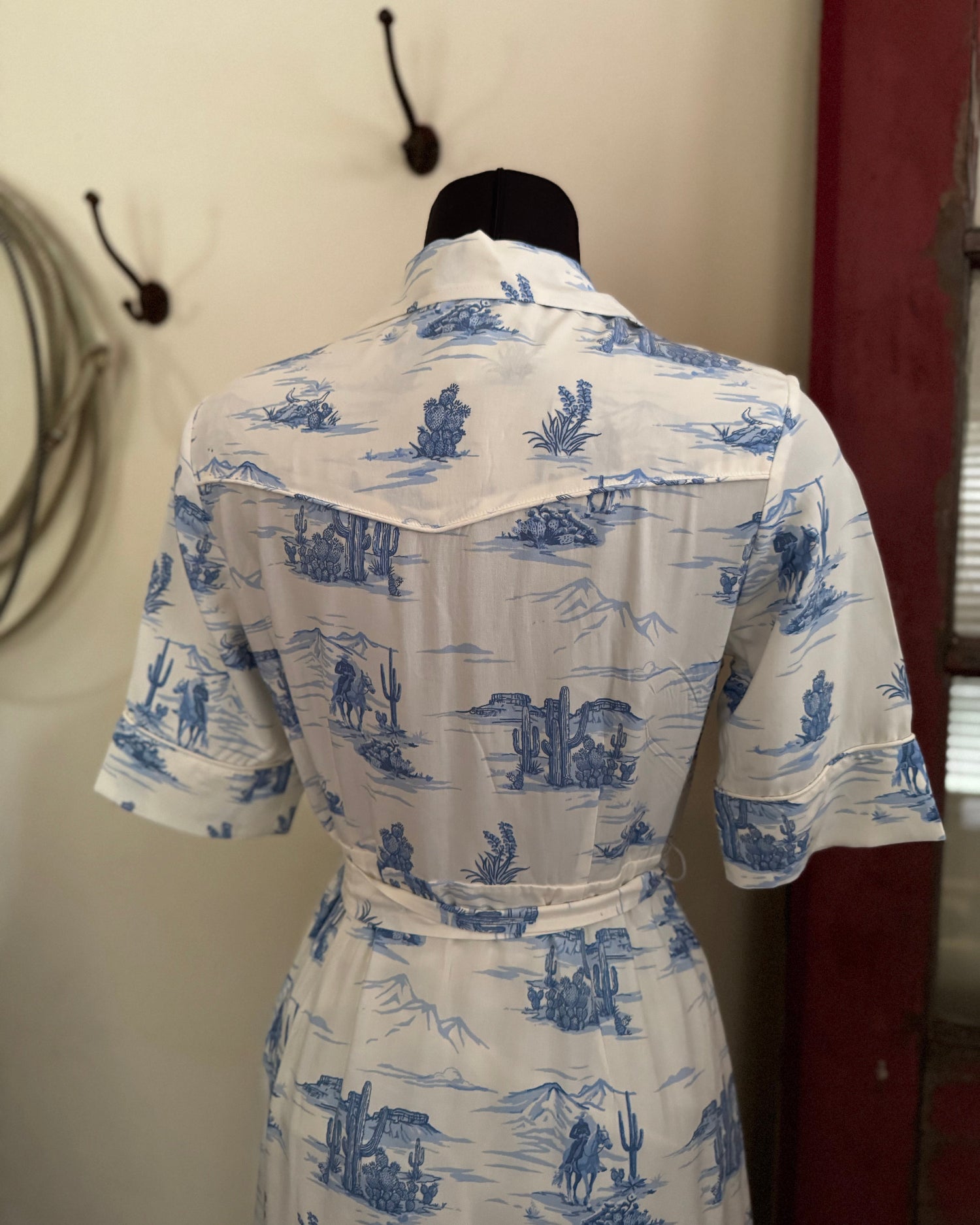 back of blue and white dress in front of a wall and red door