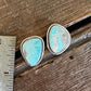 Turquoise stone earrings on a wooden surface with a ruler for scale.