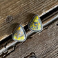 Teardrop-shaped earrings with a natural pattern on a wooden surface