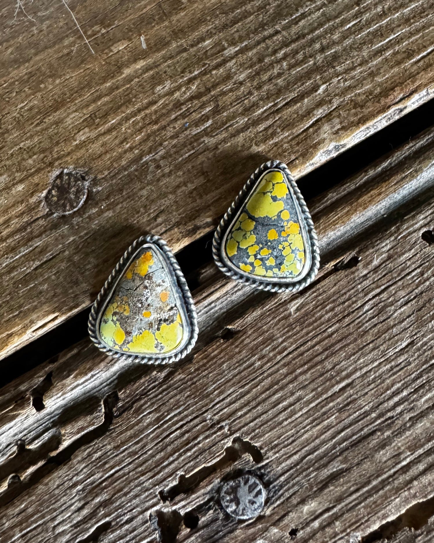 Teardrop-shaped earrings with a natural pattern on a wooden surface