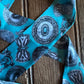 Turquoise ribbon scarf
 with black decorative patterns on a wooden surface