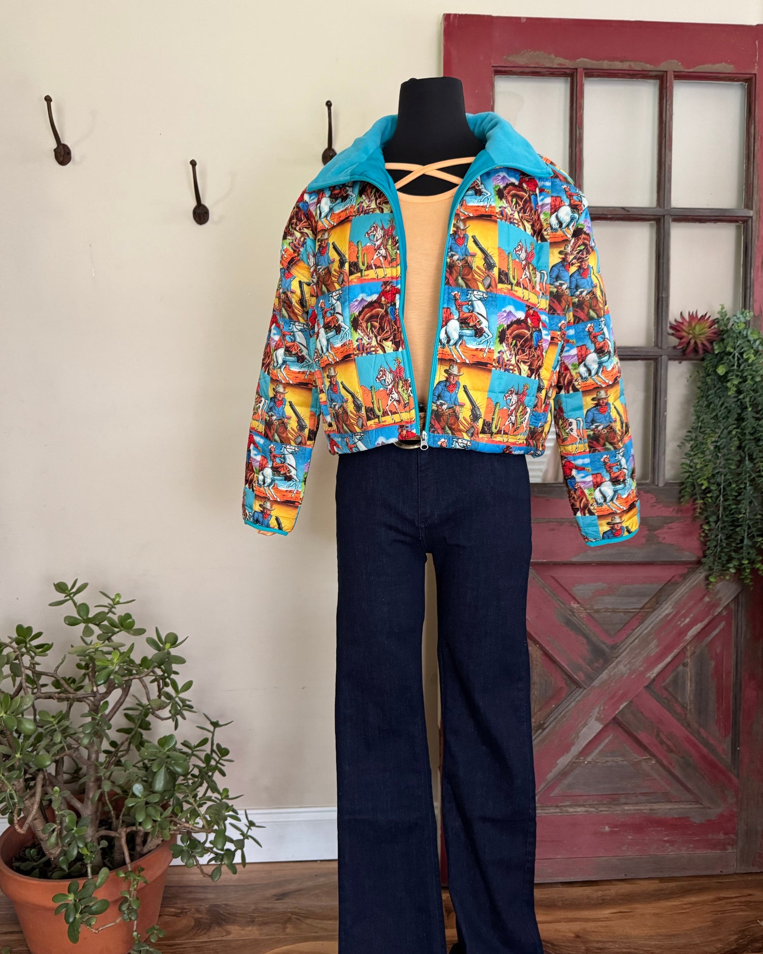 Colorful jacket with cartoon design on a wooden floor next to a plant